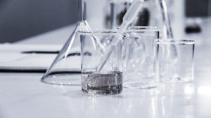 white laboratory tabletop with glass vials and instruments